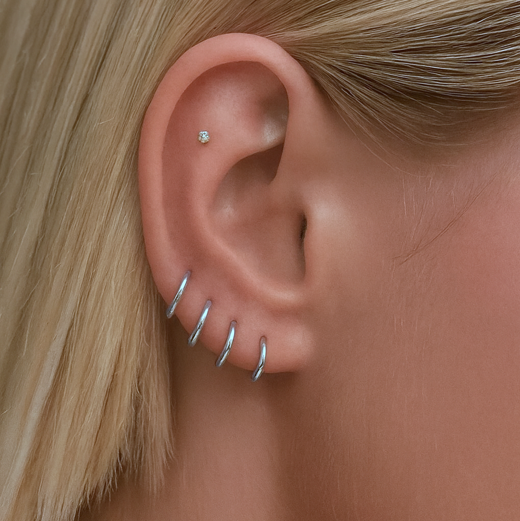 Color:Silver
Close-up of an ear with silver earrings and a small stud.